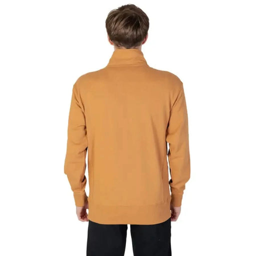 Man wearing Mustard Yellow Turtleneck Sweater from New Balance Men Sweatshirts viewed from behind