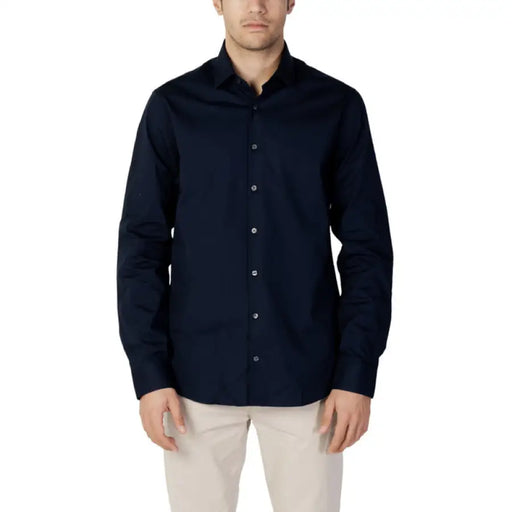 Navy blue Calvin Klein button-down dress shirt worn by a man