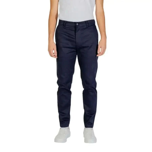 Navy blue chino pants worn by a model showcasing Calvin Klein Men Trousers