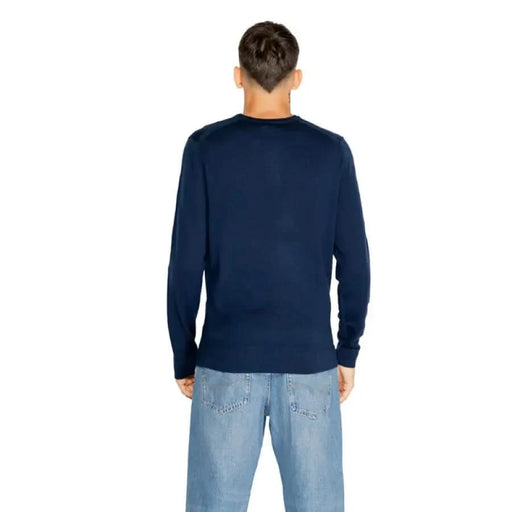 Navy blue long-sleeved sweater by Calvin Klein worn by a person from behind