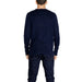 Navy blue long-sleeved crewneck sweater styled with dark jeans for men by Tommy Hilfiger