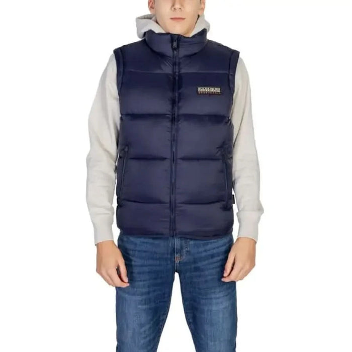 Navy blue puffer vest with logo patch over light gray sweatshirt by Napapijri