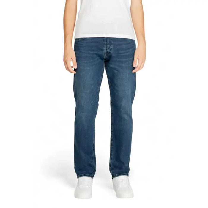 Pair of straight-leg blue jeans worn by a person, featuring Jack & Jones branding