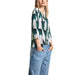 Patterned blouse with green and white shapes paired with light blue jeans by Street One