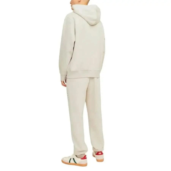 Person in light hooded sweatsuit and colorful sneakers from Jack & Jones