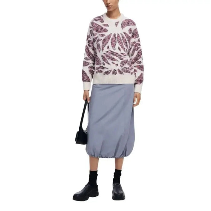 Person in a patterned sweater and blue skirt, featuring Desigual Women Knitwear