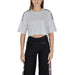 Person in a white cropped Moschino Underwear T-shirt and black track pants with stripes