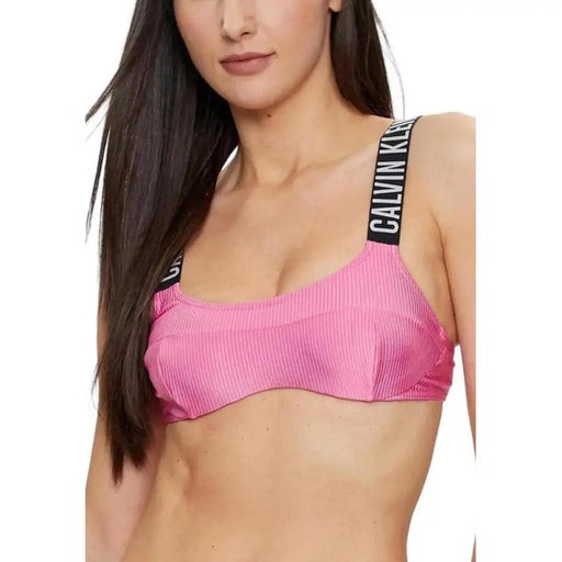 Pink sports bra with black straps featuring text from Calvin Klein Women Beachwear