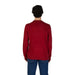 Red knit sweater for men in cotton-cashmere blend worn with blue jeans from behind