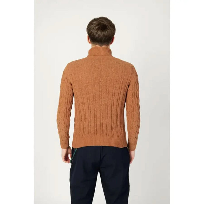 Rust-colored cable knit turtleneck sweater worn by a person from behind, Gianni Lupo