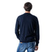 Back view of a model in navy blue Armani Exchange sweatshirt and blue jeans for men