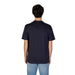 Back view of a person in a navy blue Gas Men T-Shirt and light blue jeans