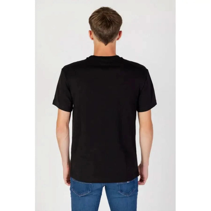 Back view of a person wearing a plain black t-shirt and blue jeans from Tommy Hilfiger Jeans Men