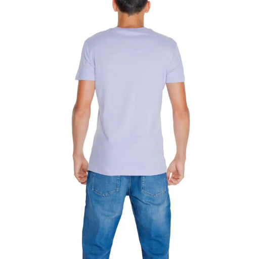 Back view of a person in a white Calvin Klein Men T-Shirt and blue jeans