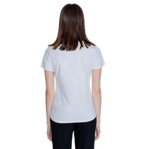 Back view of a person in a white Morgan De Toi t-shirt and dark pants