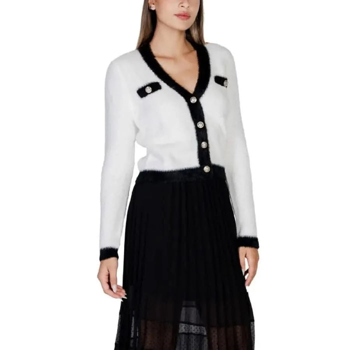 White cardigan with black trim over a black skirt from Morgan De Toi Women Knitwear