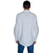 White long-sleeved button-down shirt paired with blue jeans by Tommy Hilfiger