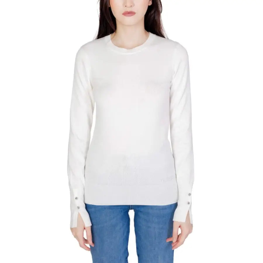 White long-sleeved crewneck sweater with blue jeans from Guess Women Knitwear collection
