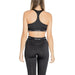 Woman in black Calvin Klein sports bra and leggings, viewed from behind, showcasing style