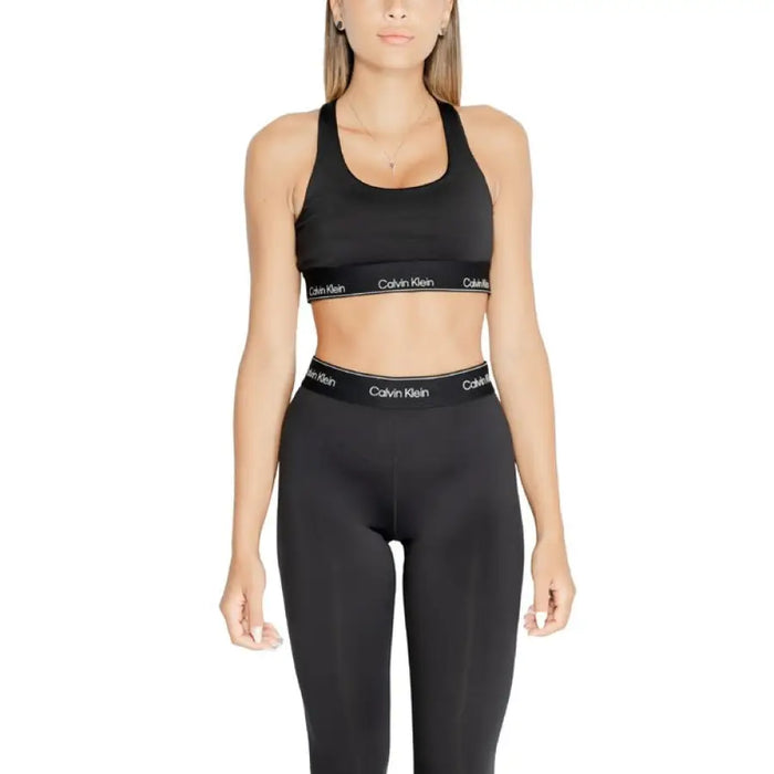 Woman in black Calvin Klein sports bra and leggings in Calvin Klein Sport collection