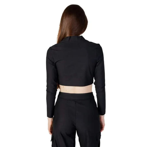 Woman in black crop top and pants, back view - Calvin Klein Jeans Women’s T-Shirt