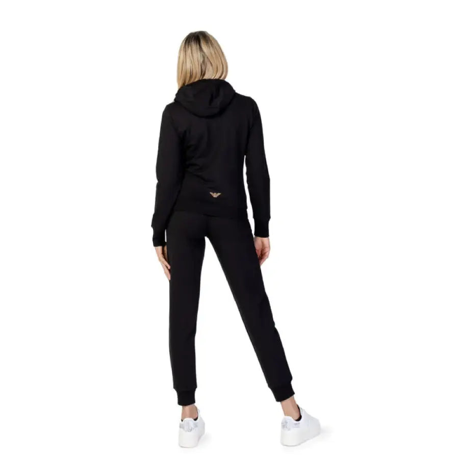 EA7 Women Jumpsuit: woman in black tracksuit and white sneakers viewed from behind