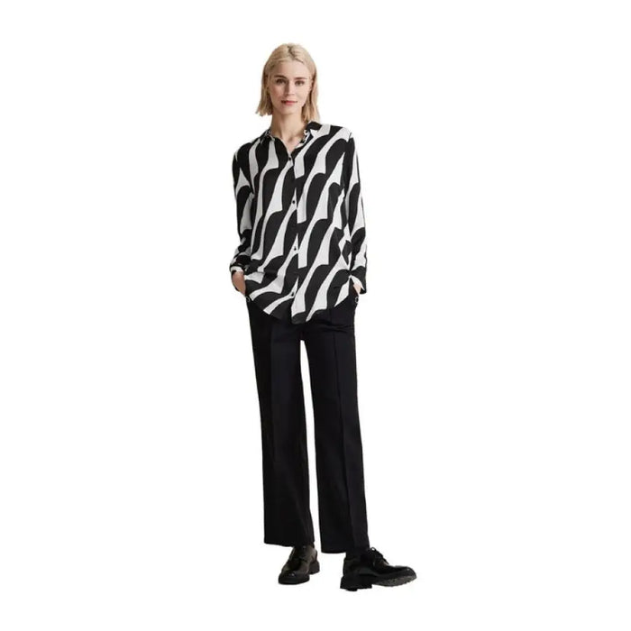 Woman in black and white zebra-print blouse paired with black trousers from Street One