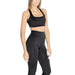 Woman in black Calvin Klein Sport workout attire with sports bra and high-waisted leggings