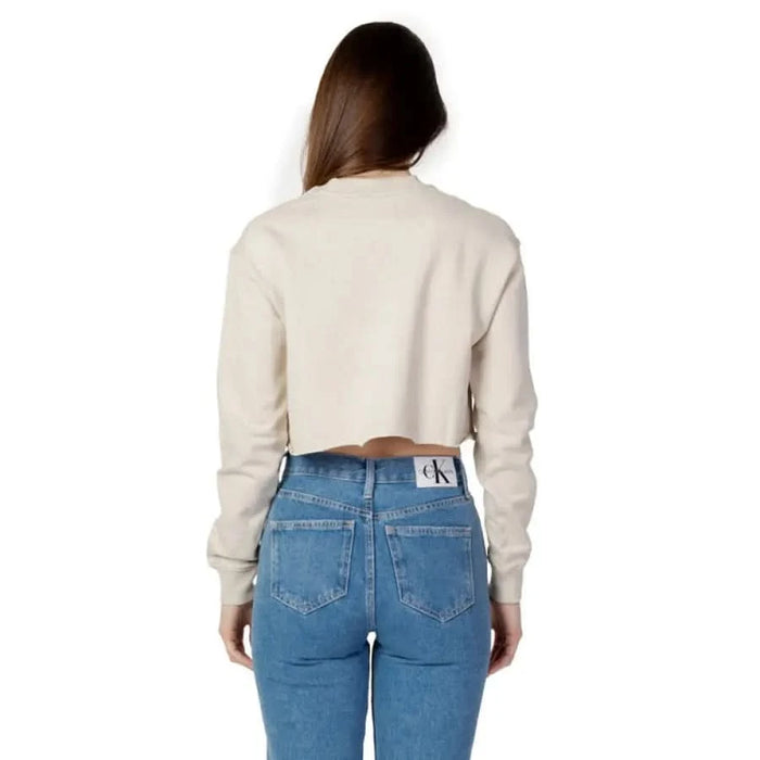 Woman in cropped cream sweater and blue jeans from behind Calvin Klein Jeans Sweatshirts