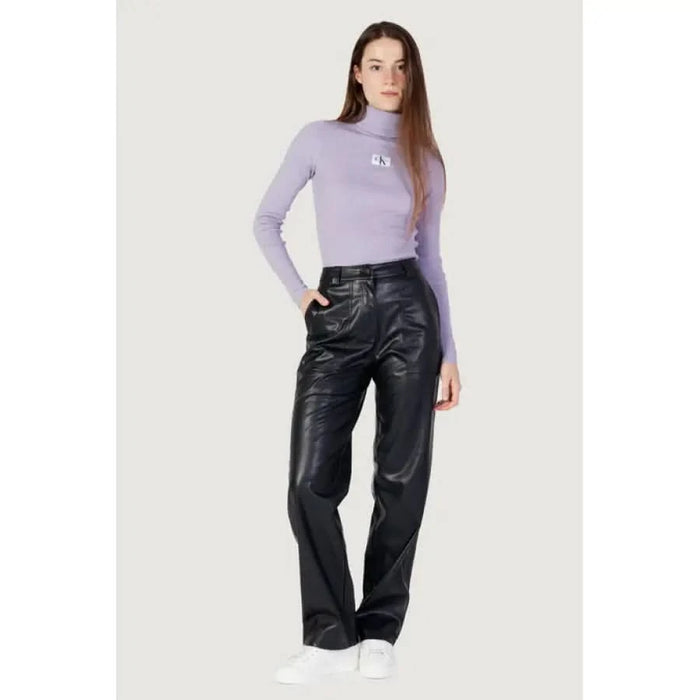 Woman in lavender turtleneck and black leather pants from Calvin Klein Jeans