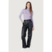 Woman in lavender turtleneck and black leather pants from Calvin Klein Jeans