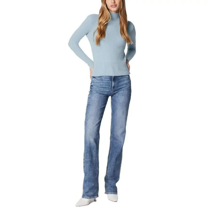 Woman in light blue sweater and blue jeans from Guess Women Knitwear collection