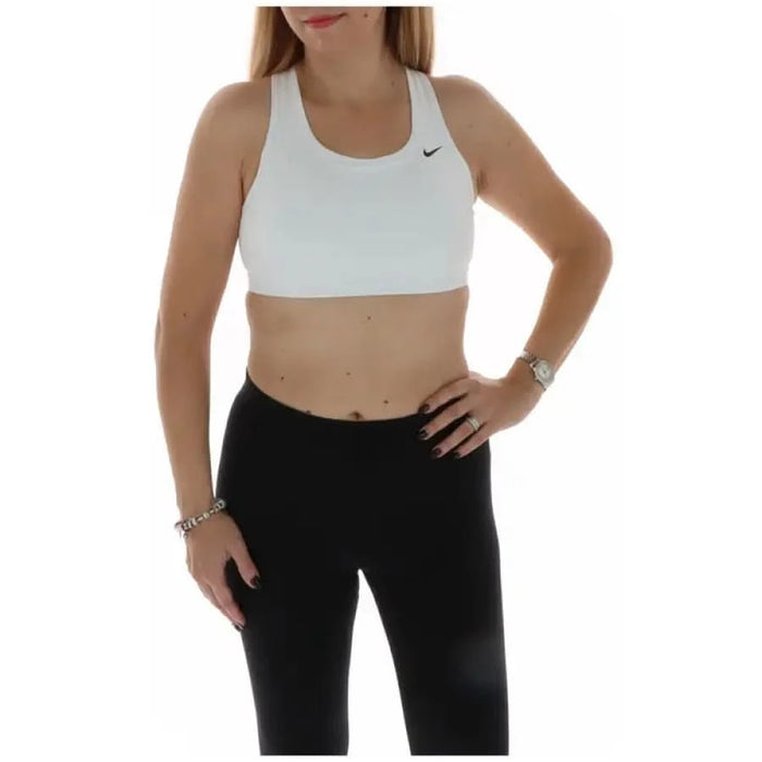 Woman in white Nike sports bra and black leggings from Nike Women’s collection