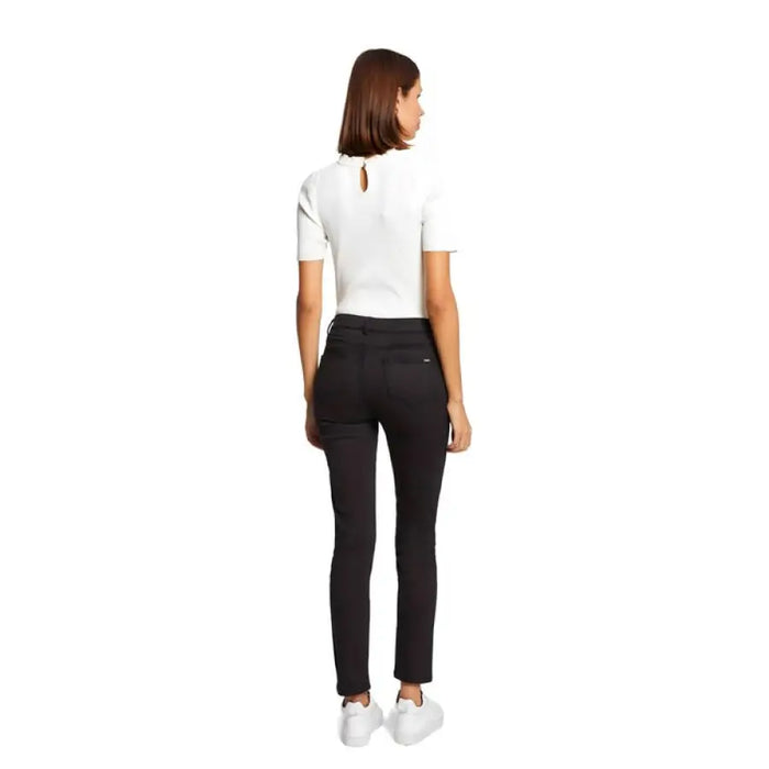 Woman in white short-sleeved top and black pants from behind, showcasing Morgan De Toi Trousers