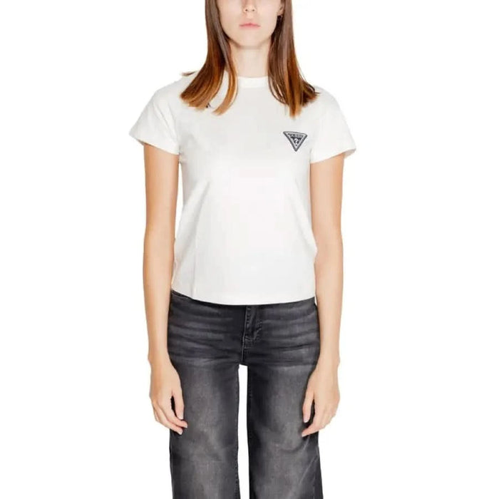 Woman in white Guess Active T-shirt with triangular logo and dark jeans