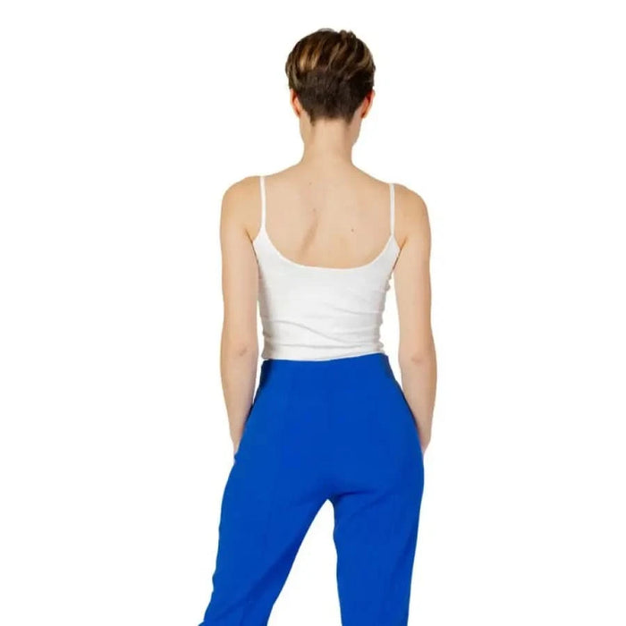 Woman wearing Guess Active undershirt in white and blue pants