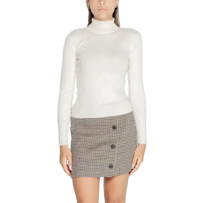 Woman in a white turtleneck sweater and plaid mini skirt from Jacqueline De Yong Knitwear